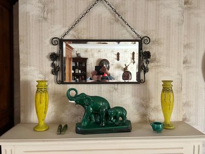 une figurine d'éléphant verte posée sur une commode