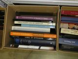 de nombreux livres qui se trouvent dans une boîte posée par terre