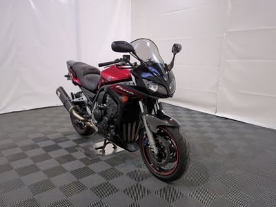 une photo d'une moto rouge et noire garée dans une pièce