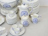 a lot of blue and white dishes and cups on the table