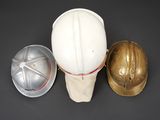two hard hats and a helmet are sitting on a table