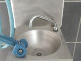 a sink with a hose attached to it in a bathroom