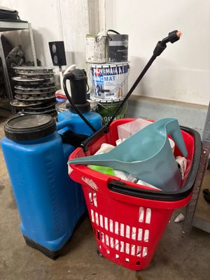 un panier rouge rempli de produits d'entretien à côté d'un bac bleu