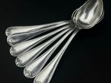 cinq cuillères posées sur une surface noire