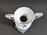 a small white cup with a blue and white design on it