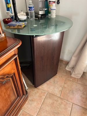 une petite table avec un plateau en verre, dans un coin de la pièce