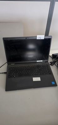 a laptop computer sitting on a desk next to a lamp