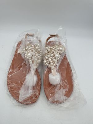 les chaussures sont emballées dans du plastique et ornées de perles