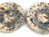 une paire d'assiettes bleues et blanches ornées de motifs mouchetés