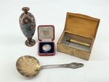 a small box with a spoon, a spoon and a spoon rest on a table