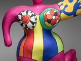 sculpture of a woman in a colorful bodysuit holding a banana
