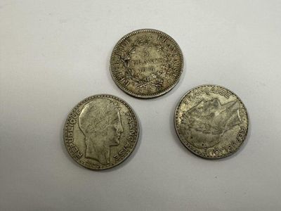 three silver coins sitting on top of a white surface
