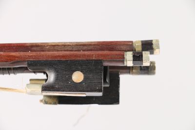 a close up of a violin bow on a white surface