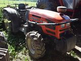 a red tractor that is parked in the grass