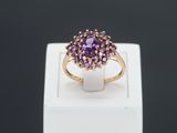 a close up of a ring with a purple stone in it