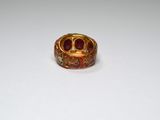 an image of a gold ring with red stones on a white surface