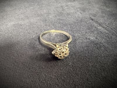 a close up of a silver ring with a flower on it