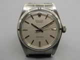 a rolex watch on a table with a white background