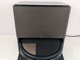 a close up of a black speaker on top of a white surface