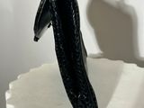 a sculpture of a black object on a white pedestal