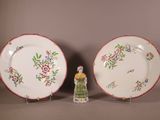 Deux assiettes et une petite figurine sont posées sur une table