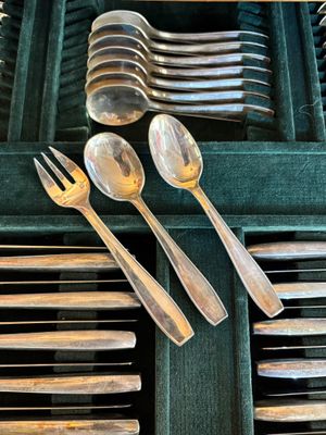 de nombreuses cuillères et fourchettes dans une boîte verte