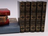 several old books are stacked on top of each other on a table