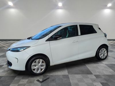 une voiture blanche garée dans une pièce au sol en damier