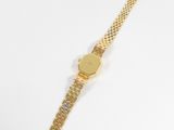 a gold watch on a white surface with a white background
