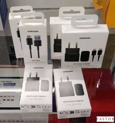 Trois boîtes d'adaptateurs secteur Samsung sont posées sur une table