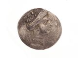 une pièce de monnaie sur laquelle figure la tête d'une femme, sur un fond blanc