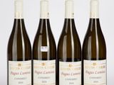 quatre bouteilles de vin sont alignées sur une surface blanche