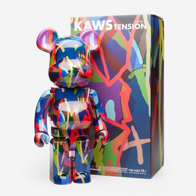 L'ours se tient devant une boîte de « Kaws Tension ».