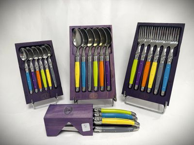 a set of spoons and forks in a purple box