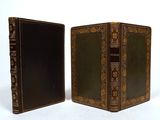 two old books sitting side by side on a white surface