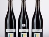 trois bouteilles de vin posées l'une à côté de l'autre sur une table