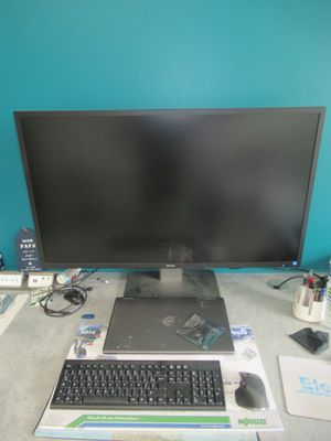 a computer desk with a monitor, keyboard, mouse, and other electronics