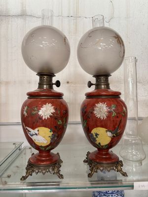 two red vases on display on a glass shelf