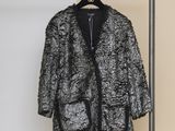 un manteau noir et blanc accroché à un porte-manteau dans une pièce