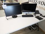 deux écrans d'ordinateur posés sur un bureau avec un clavier et une souris
