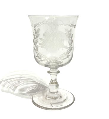 a glass with a design on it sitting on a table