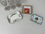 a small tray with a picture of a bird on it next to glasses and a tray with a picture of a bird on it
