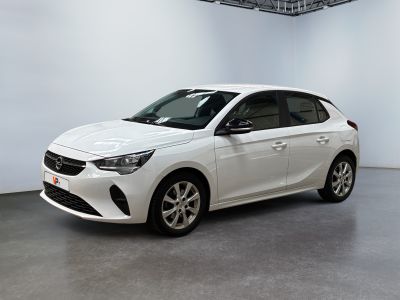 La voiture blanche est garée dans une grande pièce aux murs blancs.