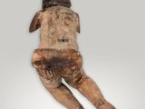 an old wooden statue of a man laying down on his back