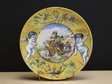 a yellow plate with a picture of angels and cherensils on it
