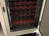 a large oven that has many trays of food inside of it