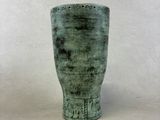 un vase vert posé sur une table