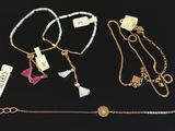 four different necklaces and bracelets on a black surface