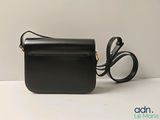 the small black bag is sitting on the table next to a pair of scissors