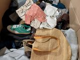 a cardboard box filled with clothes and a handbag